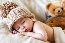 Baby S Brown Knitted Bobble Hat Sleeping