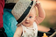 Baby S White Sleeveless Top Playing With Hat