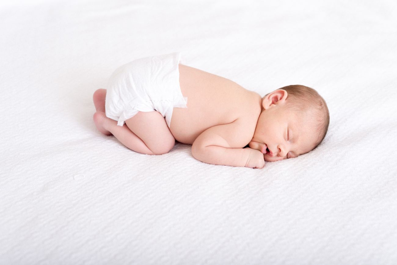 Baby in White Diaper Sleeping on White Cushion